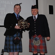 Pipe Major Robert Mathieson presented with the overall winners award at the Lomond & Clyde Pipe Band 10th Anniversary Invitational Indoor Competition (Picture courtesy of Lomond & Clyde Pipe Band)